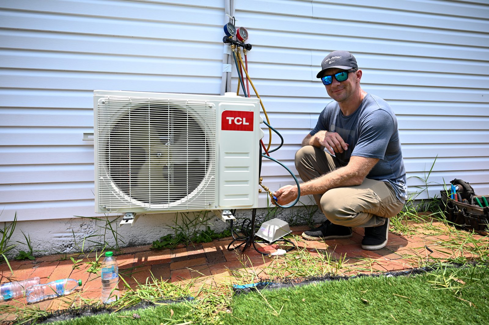 HVAC technician checking refrigerant gauges on an outdoor AC unit